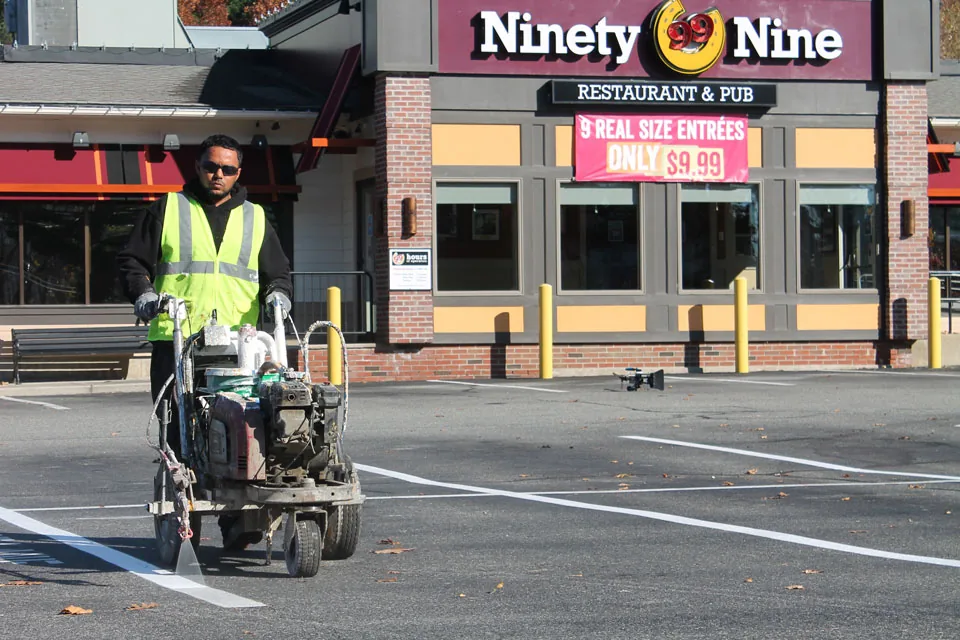 us pavement employee line striping a parking lot