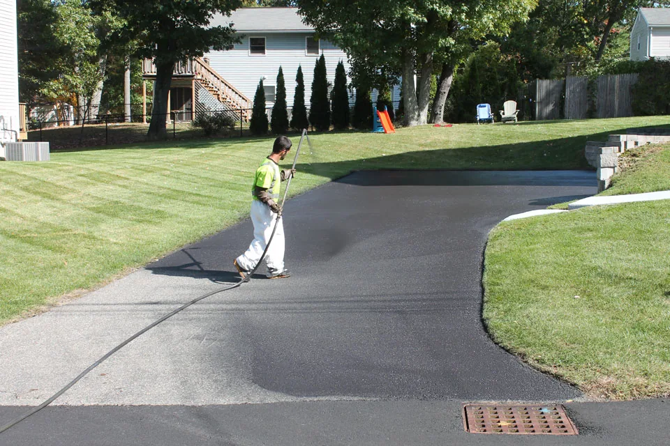 U.S. Pavement employee sealcoating a driveway
