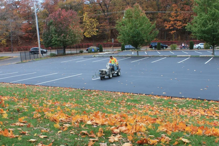 u.s. pavement employee operating a line striping machine in a parking lot