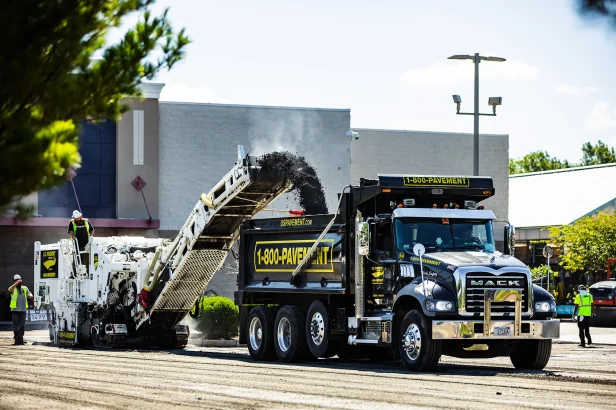us pavement cold planer loading asphalt millings into a dump truck