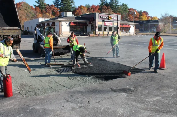 us pavement employees patching asphalt